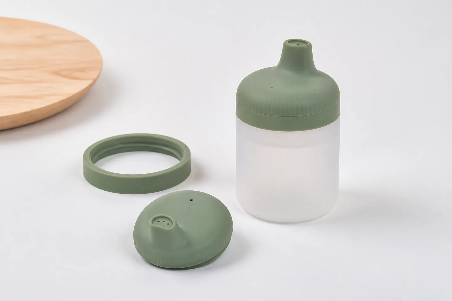 Custom silicone baby sippy cup with translucent body and sage green spout lid components